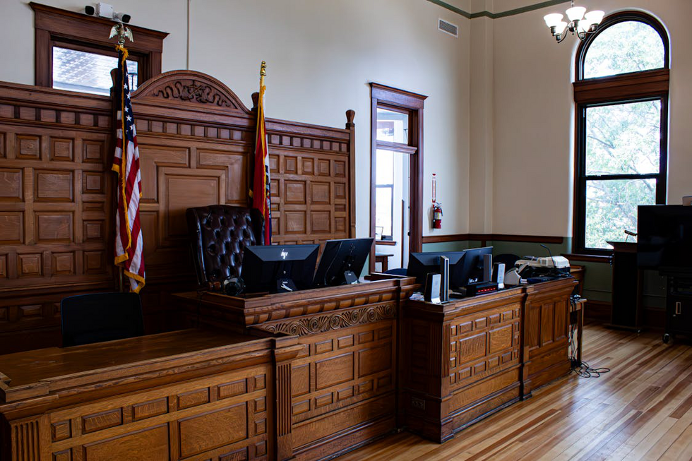 Interior of a courtroom showing benches, judge’s podium, and legal proceedings