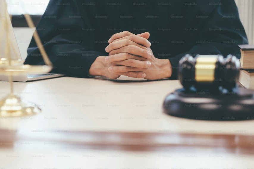 A man sitting with his hands clasped together.