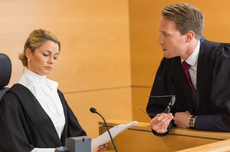 A judge and a lawyer talking in a court room.