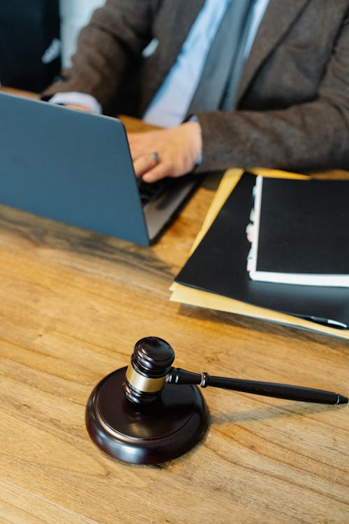 An image of gravel on a table as a person types on a laptop